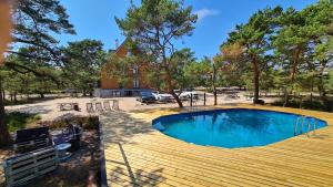 a swimming pool on a deck next to a house at Na Wydmach. Spokój. Cisza. Las dookoła in Hel