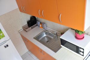 eine kleine Küche mit einer Spüle und einer Mikrowelle in der Unterkunft City center in Brčko