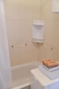 ein Badezimmer mit einer Badewanne, einem Waschbecken und Handtüchern in der Unterkunft City center in Brčko