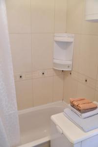 a bathroom with a tub and a sink and towels at City center in Brčko +2 photos