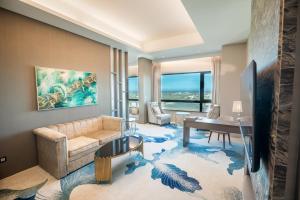 a living room with a couch and a table and a desk at Grand Hotel Lili in Taitung City
