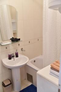 a white bathroom with a sink and a shower at City center in Brčko