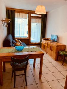 ein Wohnzimmer mit einem Tisch und einer Person auf einer Couch in der Unterkunft Appartamento Numero2 - Edelweiss Pila in Pila