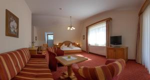 ツェル・アム・ツィラーにあるHotel Garni Elisabethのベッドとリビングルームが備わるホテルルームです。