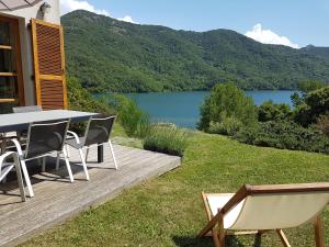 a table and chairs on a deck with a view of a lake at Côté Lac Tolla in Tolla