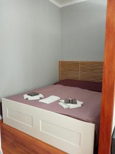 a bedroom with a bed with two towels on it at Apartament CENTRUM in Giżycko