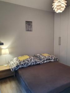 sypialnia z łóżkiem i żyrandolem w obiekcie Apartament nad Sapiną w Kruklankach