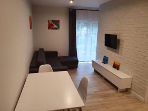 a living room with a white table and a couch at Apartament nad Sapiną in Kruklanki