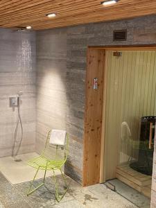 a green chair sitting in front of a shower at Hôtel LAPIAZ & Spa - FLAINE in Flaine