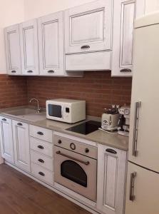 cocina con armarios blancos y microondas blanco en Vie d'acqua Al Morelo - City Center-BO en Bolonia