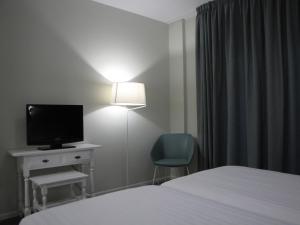Televízia a/alebo spoločenská miestnosť v ubytovaní Hotel Ton