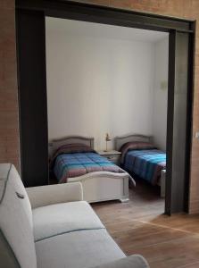 Sala de estar con 2 camas y espejo en Vie d'acqua Al Morelo - City Center-BO en Bolonia