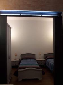 1 dormitorio con 2 camas y una luz en la pared en Vie d'acqua Al Morelo - City Center-BO, en Bolonia