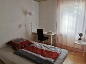 1 dormitorio con 1 cama con escritorio y silla en Gemütliche 90 qm Wohnung in Saarburg, zentral gelegen, Garten mit Aussicht, separater Eingang en Saarburg