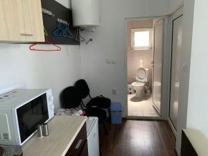 a small kitchen with a microwave and a toilet at Shabla Lux Guest Houses in Shabla