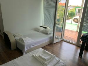 a bedroom with a bed and a sliding glass door at Shabla Lux Guest Houses in Shabla