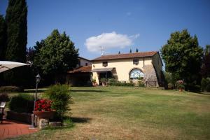 une maison avec une pelouse devant elle dans l'établissement Casa vacanze Casalsole, à Vinci