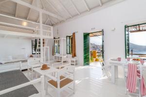 a room with white furniture and large windows at Atlantis Houses in Halki
