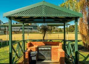 un pabellón con una mesa y dos cubos de basura en Deniliquin Country Club Motor Inn, en Deniliquin