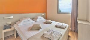 ein Schlafzimmer mit zwei Betten mit Handtüchern darauf in der Unterkunft DIEHOLIDAYBUCHT in Biograd na Moru