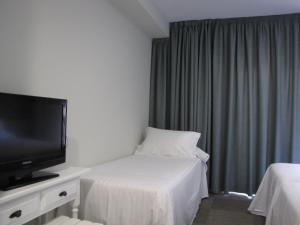 サンシェンショにあるHotel Tonのベッド1台、薄型テレビが備わるホテルルームです。