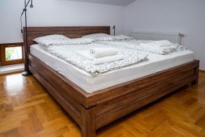 een groot houten bed met twee witte handdoeken erop bij WONDER CRACOW in Krakau