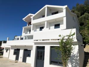 a white building with a blue sky in the background at Apartments Palit Rab in Rab