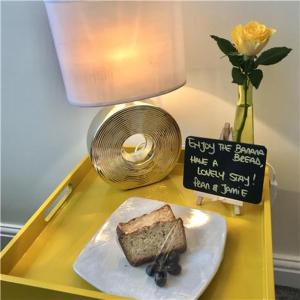 un tavolo giallo con un pezzo di pane e un vaso con un fiore di St. Raphael Guest House a York