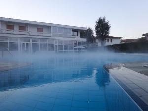 a swimming pool with steam coming out of the water at Hotel Terme Marconi in Montegrotto Terme