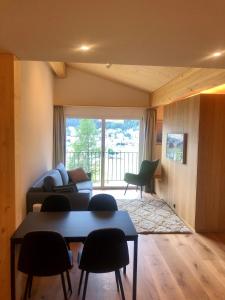 ein Wohnzimmer mit einem Sofa, einem Tisch und Stühlen in der Unterkunft Studio Mattawaldstrasse 17A in Davos