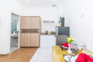 a kitchen with a table and a refrigerator at An Bình House Saigon in Ho Chi Minh City