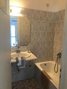 a bathroom with a sink and a tub and a mirror at Romantika in Platis Gialos