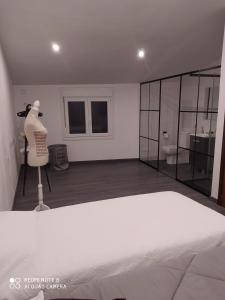 a bedroom with a white bed and a mirror at Casa de la Abuela en el Camino de Santiago a Finiesterre in Negreira