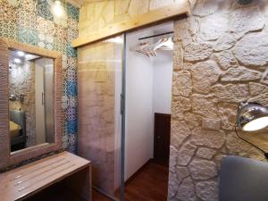a bathroom with a mirror and a stone wall at Proserpina in Enna