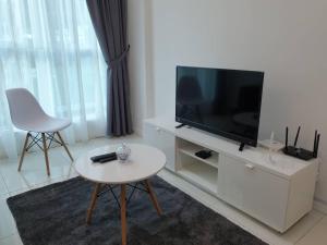 a living room with a flat screen tv and a table at FLYPOD - Blue Sky Apartment 4-5pax , Sutera Avenue in Kota Kinabalu