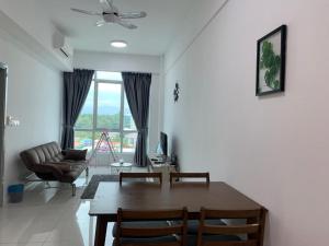 a living room with a table and a couch at FLYPOD - Blue Sky Apartment 4-5pax , Sutera Avenue in Kota Kinabalu