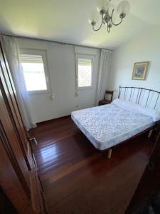 1 dormitorio con 1 cama y 2 ventanas en apartamento con vistas al mar y la montaña, en Santa Marta de Ortigueira