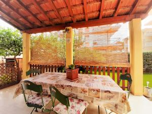 una mesa y sillas en un patio con ventana en Villa la Casetta con giardino a 30 m dal mare, en San Bartolomeo al Mare