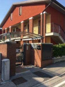 Un edificio de ladrillo rojo con una puerta delante. en Apt 23 Residence delle Rose, en Peschiera del Garda