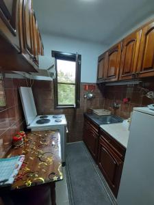 - une cuisine avec des placards en bois et un comptoir dans l'établissement Apartmani Perovic, à Sokobanja