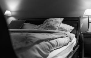 una foto en blanco y negro de una cama sin hacer en Country House Duinhof en De Haan