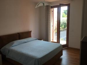 Un dormitorio con una cama y una puerta corrediza de vidrio. en Apt 23 Residence delle Rose, en Peschiera del Garda
