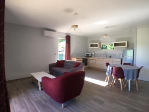 a living room with a couch and a table and a kitchen at Hameau de Biscaye in Varetz