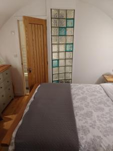 a bedroom with a bed and a door with glass panels at Pell Dell Apartment in Holmfirth