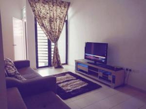 a living room with a couch and a flat screen tv at Pok Su Homestay Balok in Kuantan