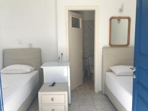 a bedroom with two beds and a mirror and a sink at Romantika in Platis Gialos