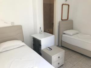 a small bedroom with two beds and a mirror at Romantika in Platis Gialos