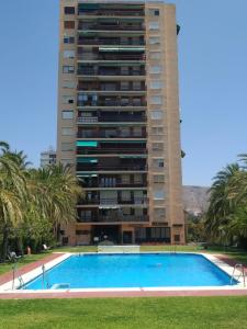 a tall building with a swimming pool in front of a building at Paseo de los Castaños con vistas in Aguadulce