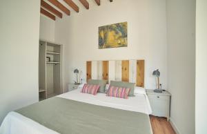 a white bedroom with a large bed with two pillows at Vila Alaró TI in Alaró