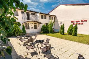 un patio con sillas y mesas frente a un edificio en B&B Duo Caffe Baneasa en Bucarest